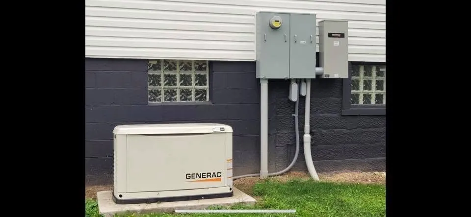 Generac standby generator on a concrete pad beside a house